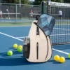 Sac sling pickleball beige posé sur un terrain extérieur